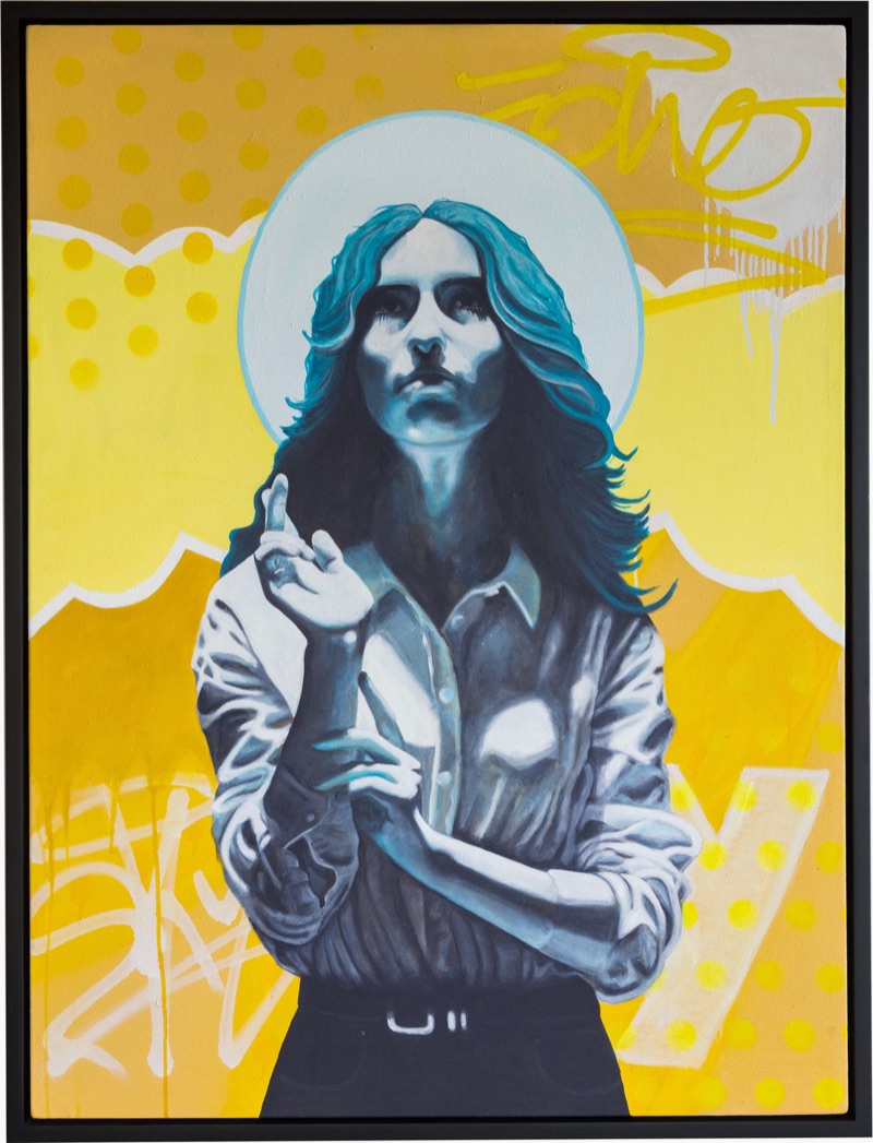 A long-haired figure painted in blue-grey tones with a pale halo, one hand raised, against a bright yellow ground scattered with graffiti marks.